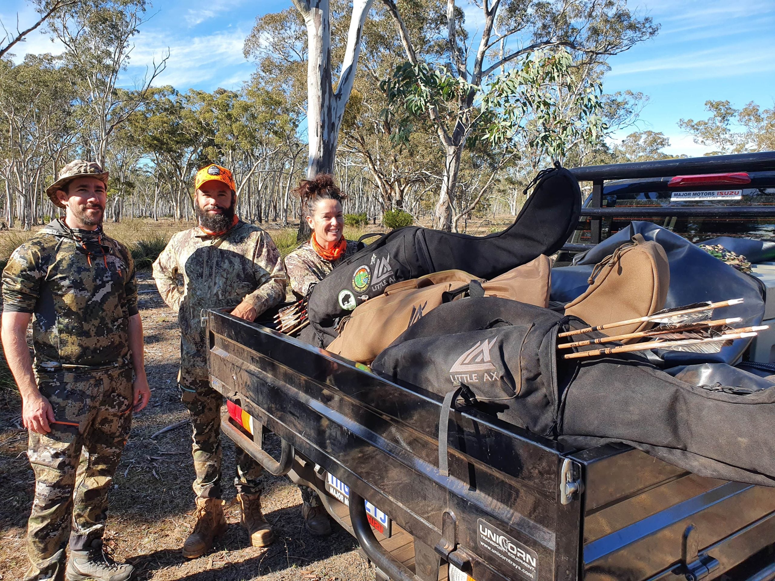 Three hunters in camouflage at a loaded ute tray with a Little Ax bow case